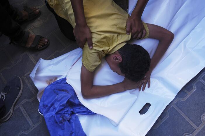 A Palestinian boy mourns over the body of his 12-year-old friend, Abdullah Ahmed, who was killed in an Israeli strike that targeted a drinking water distribution point, at Al-Awda Hospital in Nuseirat, central Gaza Strip, Sunday, July 13, 2025.