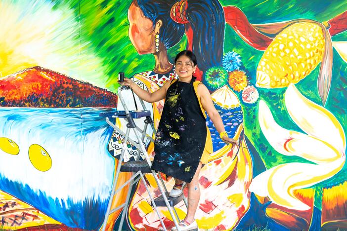 Evelyn del Rosario Morán Cojoc, an artist from Guatemala, creates a mural that depicts traditional foods from her Mayan culture — like that floating ear of corn and three yellow beans. She teaches art to kids across the country, encouraging them to depict their indigenous traditions.
