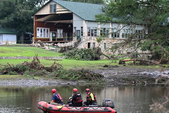 A search and rescue team looks for people along the Guadalupe River near a damaged building at Camp Mystic. Federal regulators repeatedly granted appeals to remove Camp Mystic's buildings from government flood maps that showed they were in an area at high risk of dangerous flooding.