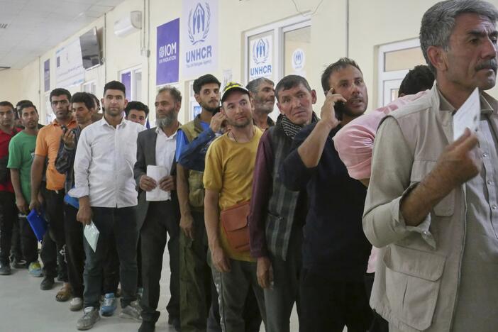 Afghan refugees who returned after fleeing Iran to escape deportation and conflict line up at a UNHCR facility near the Islam Qala crossing in western Herat province, Afghanistan, on Friday, June 20, 2025.