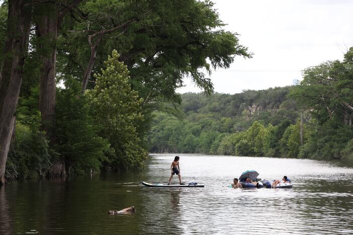 People swim in the Blanco River by a low water crossing on River Road across from 7A Ranch in Wimberley, Texas, on July 9.