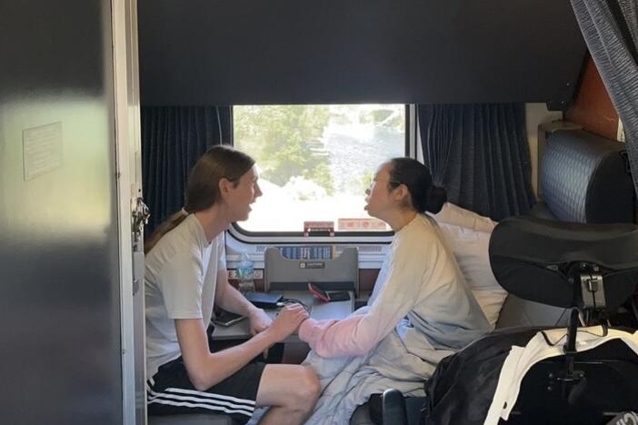 Peter Saathoff-Harshfield and Aubrie Lee hold hands while in their accessible room on the California Zephyr Amtrak train.