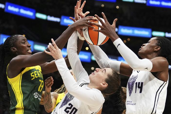Golden State Valkyries guard Kate Martin (20) struggles to maintain possession against Seattle Storm forward Ezi Magbegor (left) as Valkyries center Temi Fagbenle (14) reaches for the ball during the second half of a WNBA game Wednesday in Seattle. The Valkyries debuted this season as the league's 13th team.