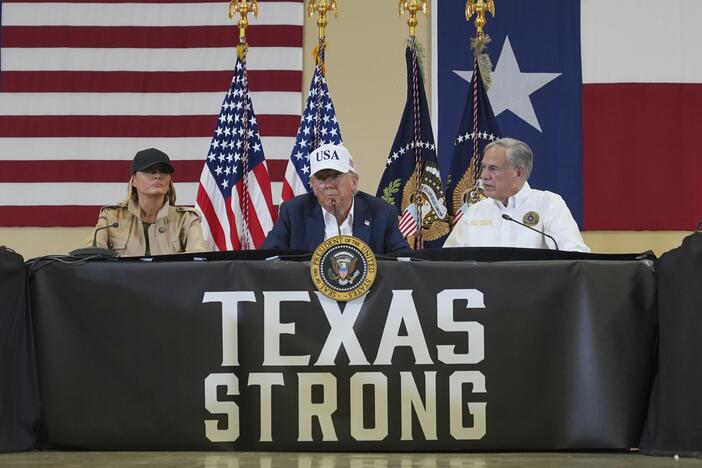 President Donald Trump speaks as first lady Melania Trump, left, and Texas Gov. Greg Abbott listen during a roundtable discussion with first responders and local officials at Hill Country Youth Event Center in Kerrville, Texas, during a tour to observe flood damage July 11.