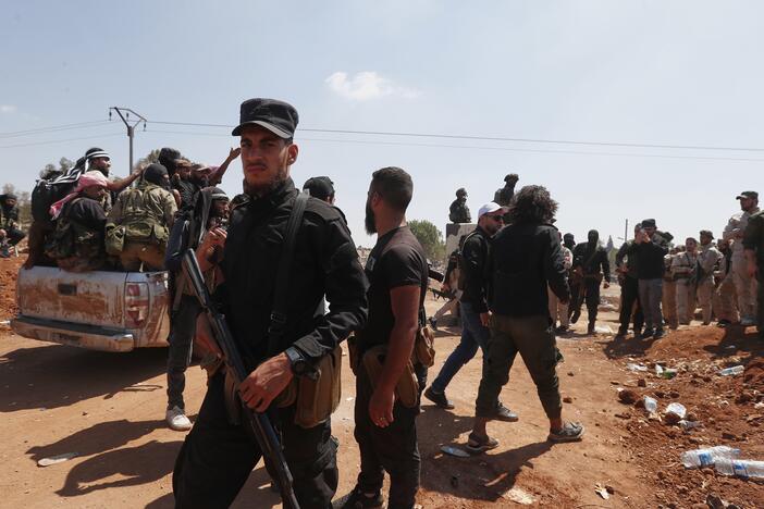 Syrian government security forces block Bedouin fighters, background, from entering Sweida province, in Busra al-Harir village, southern Syria on Sunday.