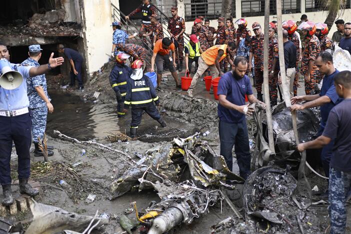 Firefighters work at the site of a Bangladesh Air Force training aircraft that crashed into a school campus shortly after takeoff in Dhaka, Bangladesh, Monday.