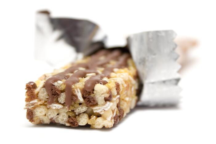 Wrapped healthy granola bar isolated on a white background.