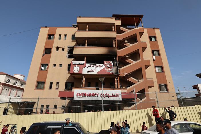 People and traffic pass the fence of the Nasser hospital in Khan Yunis which was hit in an Israeli strike at dawn that targeted the southern Gaza Strip city on May 13, 2025.