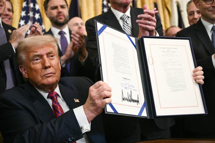 President Trump displays the GENIUS Act — the first major crypto legislation passed by Congress — after signing it in the White House in Washington, D.C., on July 18, 2025.