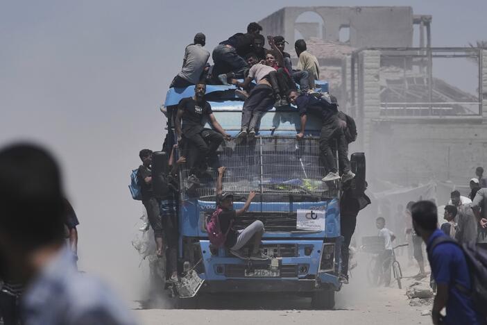 Palestinians hold onto an aid truck returning to Gaza City from the northern Gaza Strip on Tuesday.