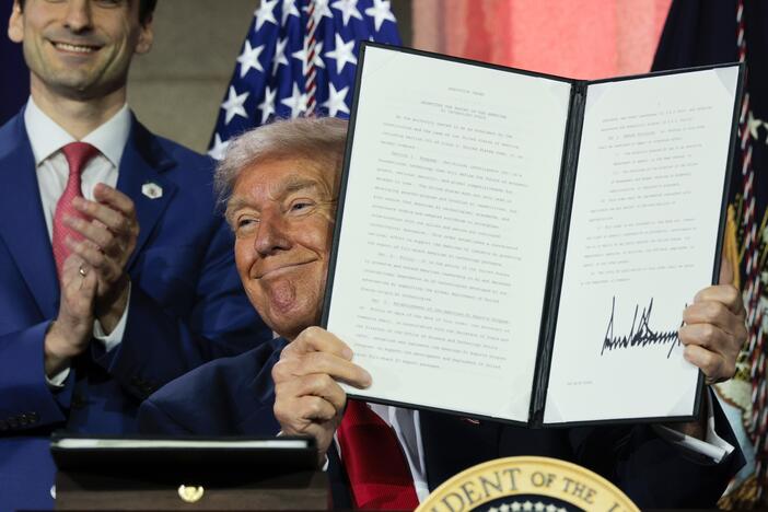 President Trump displays a signed executive order after delivering remarks on his AI plan at the Andrew W. Mellon Auditorium on July 23, 2025 in Washington, DC.