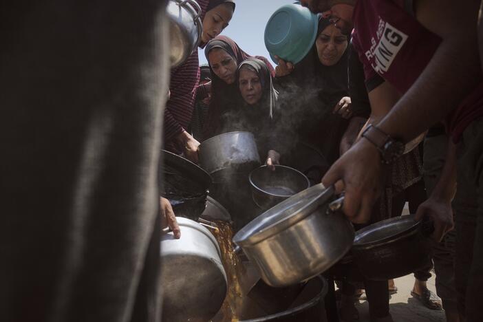 Displaced Palestinians receive donated food at a community kitchen in Gaza City, northern Gaza Strip on Tuesday.