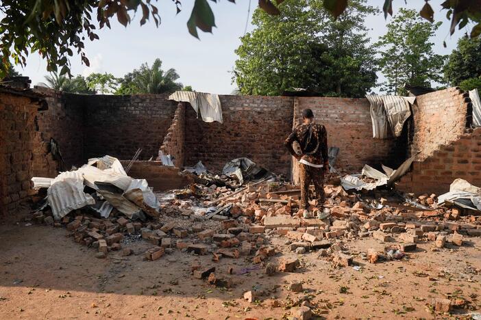 A man stands in front of a damaged and burnt house following a deadly gunmen attack in Yelwata, Benue State, Nigeria, on June 16, 2025.