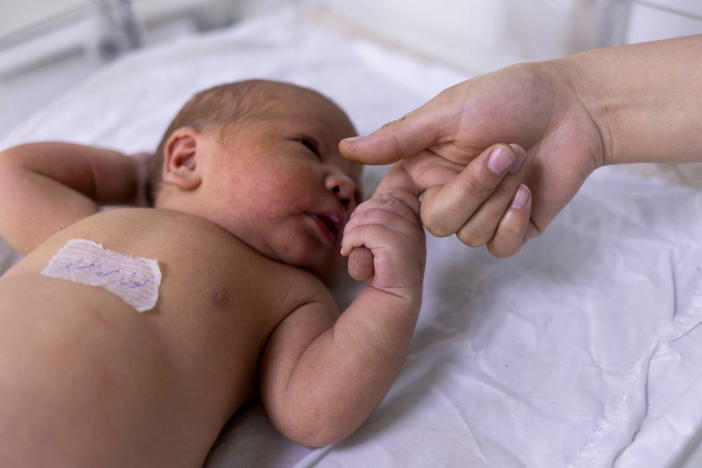 FILE PHOTO: A newborn baby holds on a nurse's finger at the maternity ward of the children hospital in Kabul, Afghanistan October 24, 2021. REUTERS/Jorge Silva/File Photo