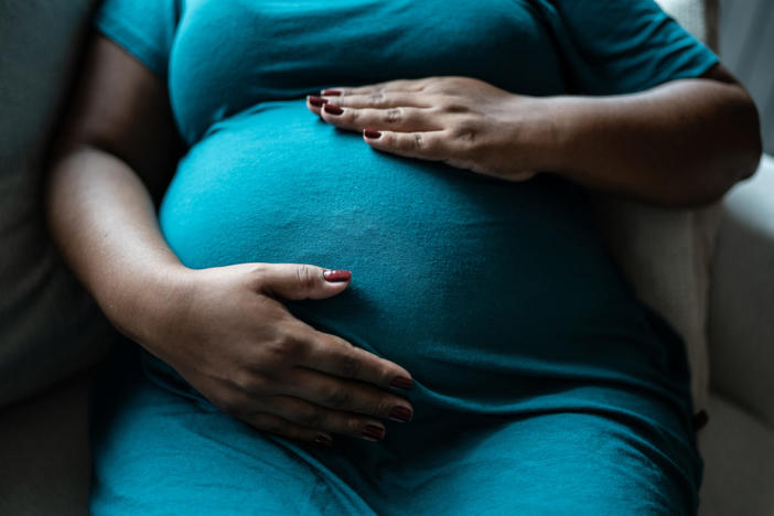 Pregnant woman touching her belly