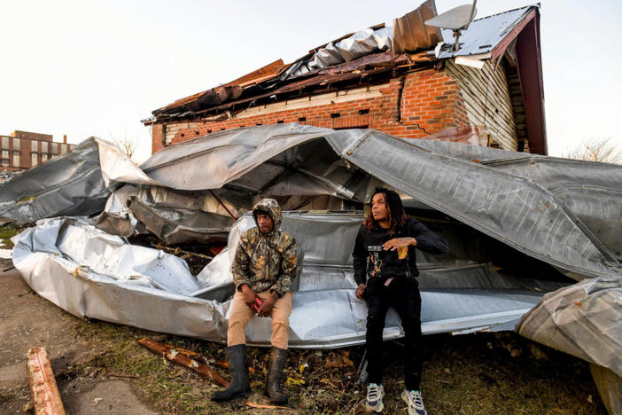 Cordel Tyus and Devo McGraw sit on roofing that blew off of an industrial building and wrapped around their house after a tornado ripped through Selma, Alabama, U.S. January 12, 2023. Mickey Welsh/USA Today Network via REUTERS NO RESALES. NO ARCHIVES. MANDATORY CREDIT