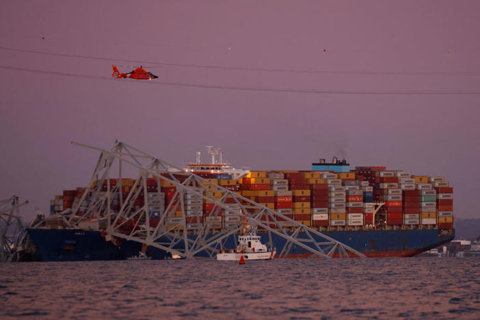 A helicopter flies over the scene of the Francis Scott Key Bridge collapse in Baltimore, Maryland, on March 26, 2024. Photo by Julia Nikhinson/ Reuters