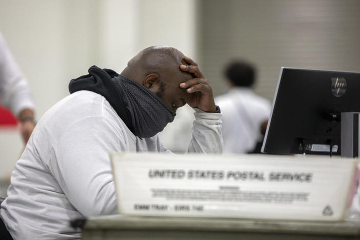 A worker with the Detroit Department of Elections inspects an absentee ballot at the Central Counting Board in the TCF Center on Nov. 4, 2020 in Detroit, Michigan. Photo by Elaine Cromie/Getty Images