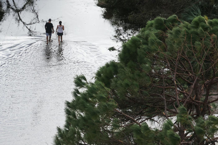 A couple walking down a flooded street after Hurricane Ian caused widespread destruction in Punta Gorda, Florida, on Sept. 29, 2022. File photo by REUTERS/Shannon Stapleton