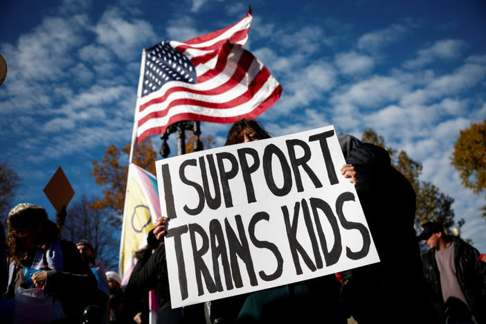 People hold signs as the U.S. Supreme Court hears arguments over an appeal by U.S. President Joe Biden's administration of a lower court's decision upholding a Republican-backed ban in Tennessee on gender-affirming medical care for transgender minors, outside the court in Washington, U.S., December 4, 2024. Photo by Benoit Tessier/ Reuters