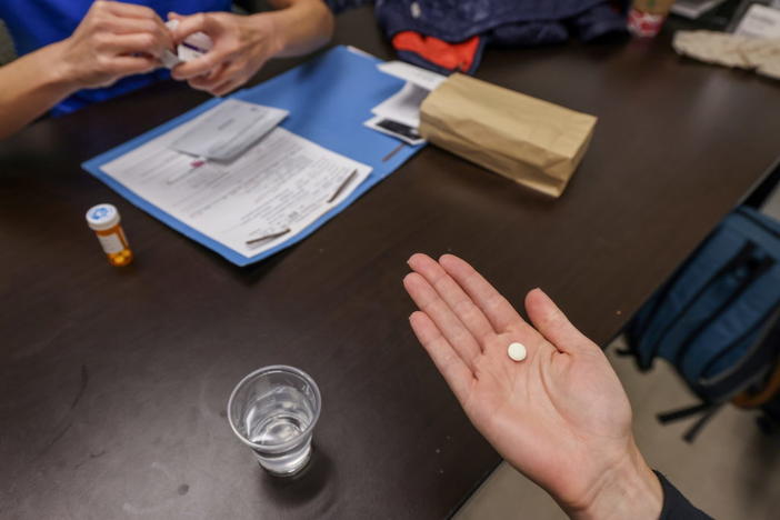 Dr. Shelly Tien hands a patient the initial abortion inducing medication at Trust Women clinic in Oklahoma City, U.S., December 6, 2021. Of the 20 abortions performed that day, 17 of the patients came from Texas. Picture taken December 6, 2021. REUTERS/Evelyn Hockstein