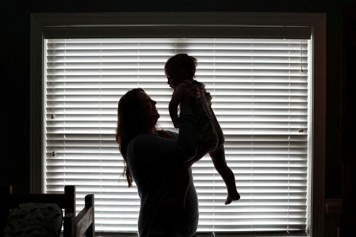 FILE PHOTO: Kristia Rumbley holds up her youngest child, in Birmingham, Alabama, U.S. Rumbley used IVF to have three children and has two more embryos frozen in case she wants another. February 23, 2024. Photo by REUTERS/Dustin Chambers