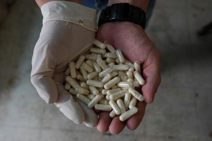 A member of the Sinaloa Cartel shows capsules with methamphetamine in a safe house in Culiacan, Mexico, April 4, 2022. To match Special report MEXICO-DRUGS/CHAPITOS REUTERS/Alexandre Meneghini