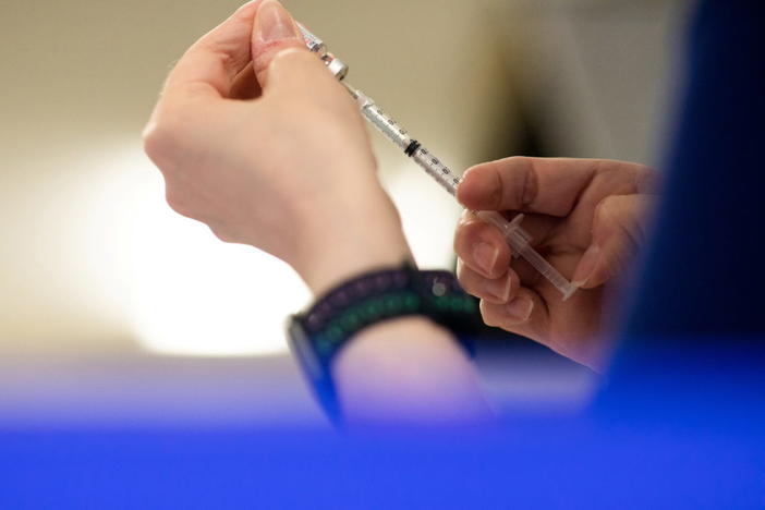 A nurse fills up syringes with the coronavirus disease (COVID-19) vaccines for residents who are over 50 years old and immunocompromised and are eligible to receive their second booster shots in Waterford, Michigan, U.S., April 8, 2022. REUTERS/Emily Elconin