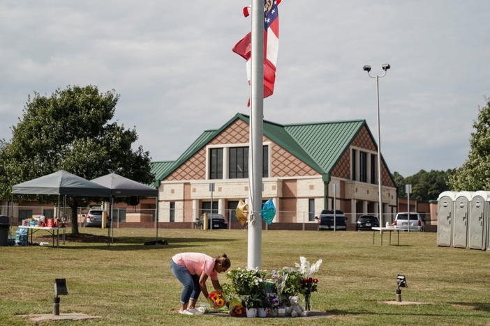 A woman lays flowers at the base of a flagpole turned into a makeshift memorial in front of Apalachee High School the day after a fatal shooting left four dead in Winder, Georgia, U.S. September 5, 2024. REUTERS/Elijah Nouvelage