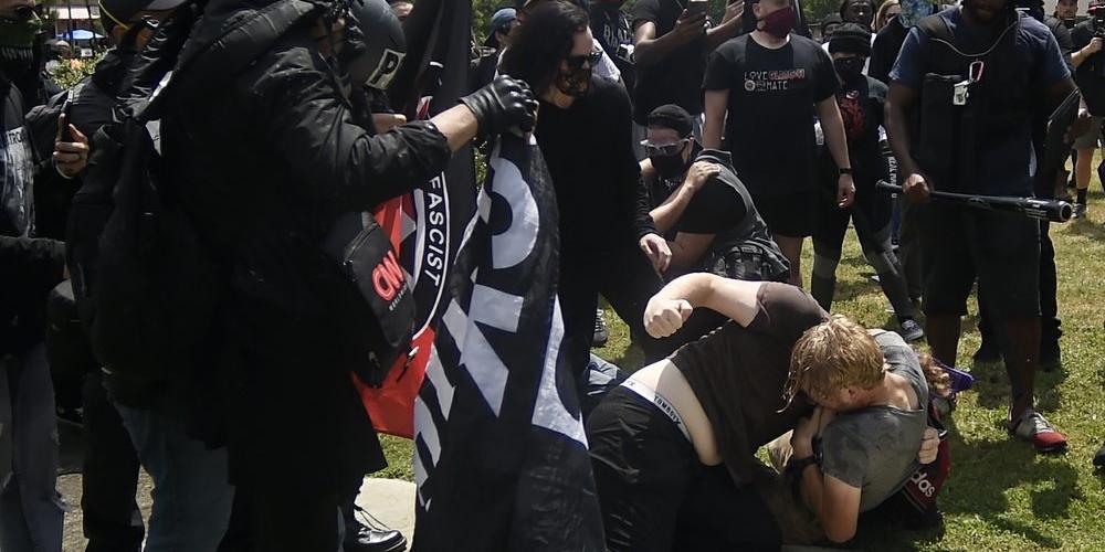 A melee breaks out during a protest, Saturday, Aug. 15, 2020, in Stone Mountain Village, Ga. Several dozen people waving Confederate flags, many of them wearing military gear, gathered in downtown Stone Mountain where they faced off against a few hundred counterprotesters, many of whom wore shirts or carried signs expressing support for the Black Lives Matter movement.