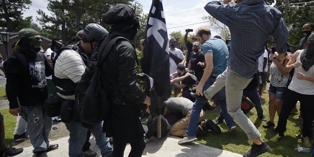 A melee breaks out during a protest , Saturday, Aug. 15, 2020, in Stone Mountain Village, Ga. Several dozen people waving Confederate flags, many of them wearing military gear, gathered in downtown Stone Mountain where they faced off against a few hundred counterprotesters, many of whom wore shirts or carried signs expressing support for the Black Lives Matter movement.