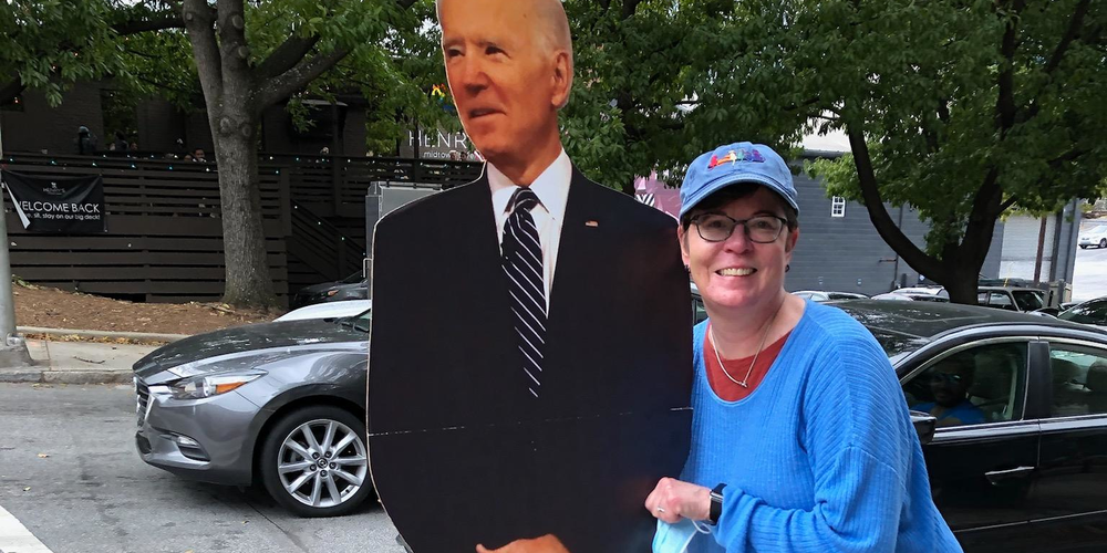 Woman next to cardboard cut out of Biden
