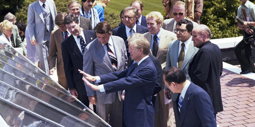 Jimmy Carter speaks to media on the roof of the White House near solar panels.