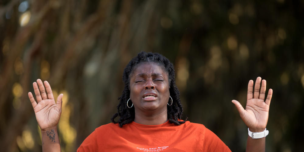 Lashay Thorpe prays during a vigil in honor of Ahmaud Arbery outside of the Glynn County Courthouse in Brunswick on Oct. 17, 2021.