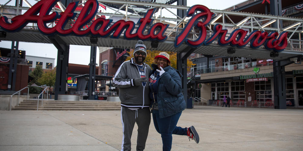 Lee and Shenelle Brown pose in front of the Atlanta Braves sign outside Truist Park. They were among the first fans to arrive early Friday, Nov. 5, 2021, to celebrate the team's World Series victory.