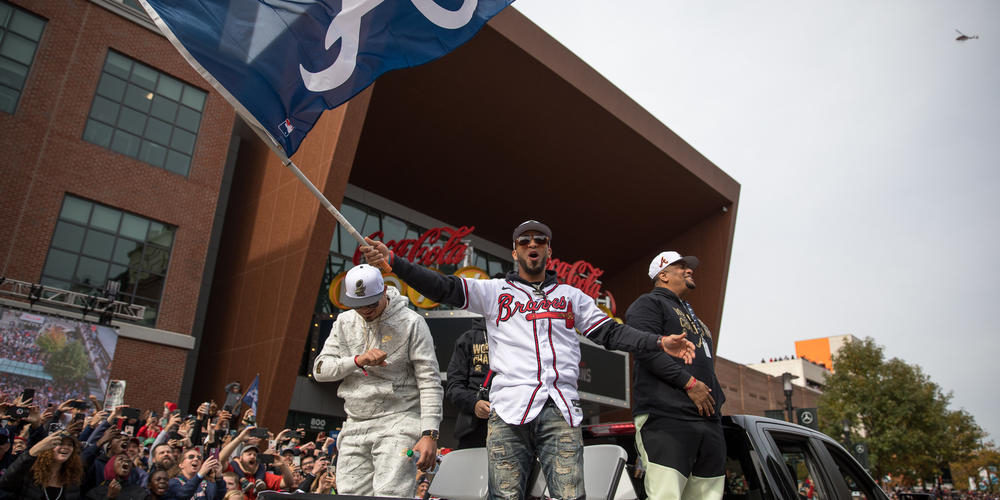 Braves left fielder Eddie Rosario waves a flag from the back of a pickup truck during the team’s celebratory parade through The Battery outside Truist Park on Nov. 5.