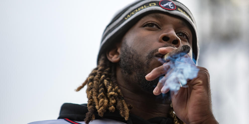 Braves pitcher Touki Toussaint smokes a cigar on stage during the teams’ World Series victory celebration at Truist Park on Nov. 5.