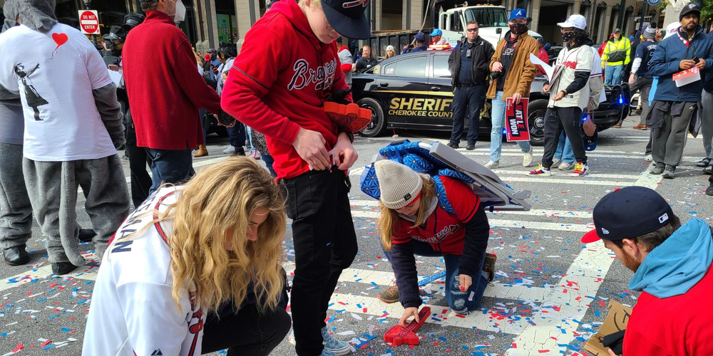 Fans pick up confetti on the streets of Atlanta, because "it's World Series confetti" of course.