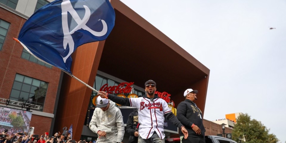 Eddie Rosario waves a Braves flag from a truck bed during the parade.
