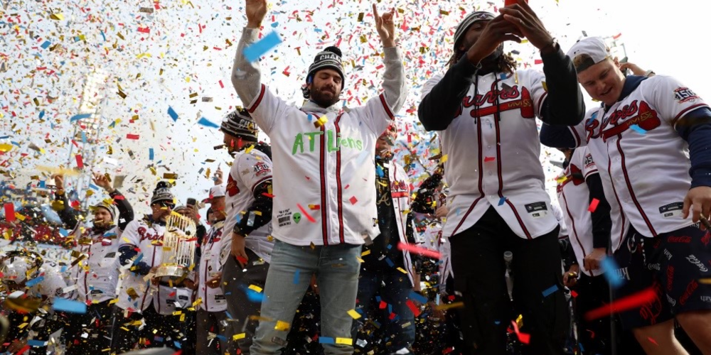 Atlanta Braves players celebrate and wave to fans in a shroud of confetti.