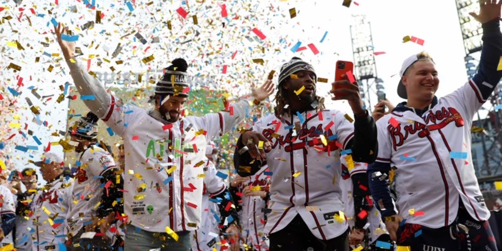 Atlanta Braves players celebrate and wave to fans in a shroud of confetti.