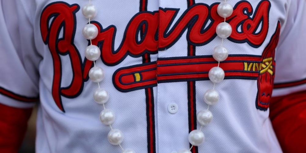 A Braves fan wears a white jersey and a pearl necklace at the celebration in Cobb County.