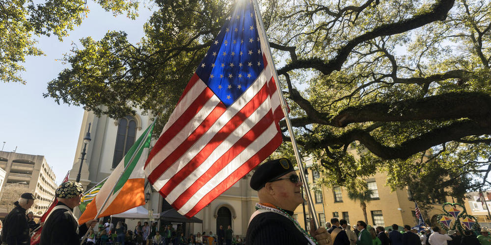 A member of The Guard Pipes and Drums of Morris and Somerset N.J., carries an American flag during the St. Patrick's Day parade, Thursday, March 17, 2022, in historic downtown Savannah, Ga. After nearly two centuries, the Irish holiday has become Savannah's most profitable tourist draw and street party for hundreds of thousands of locals and visitors. 
