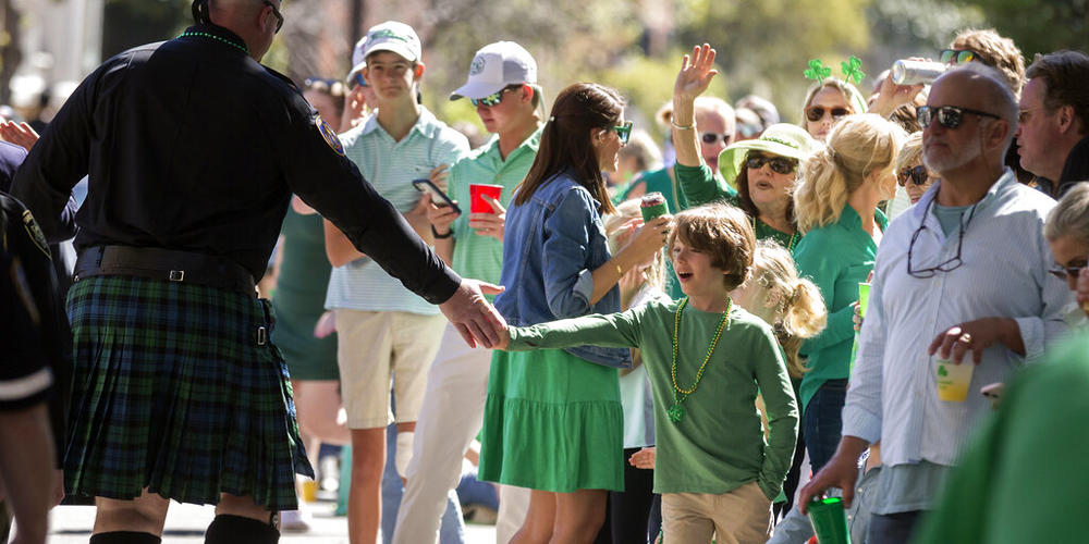 A young boy gets a high-five from law enforcement officer marching with the Police Emerald Society of Southeast Georgia during the St. Patrick's Day parade, Thursday, March 17, 2022, Savannah, Ga. After nearly two centuries, the Irish holiday has become Savannah's most profitable tourist draw and street party for hundreds of thousands of locals and visitors.