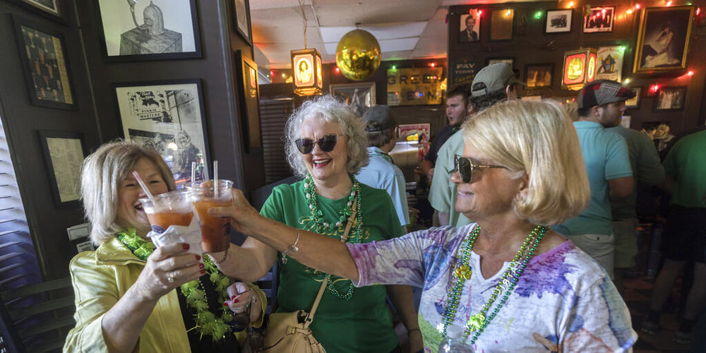 Maxine Calloway, center, of Cornelia Ga., her friends, Missy Jarrott, right, of Savannah, Ga., and Carolyn Duncan, left, of Bremen, Ga., toast to their 52 year friendship before the start of the St. Patrick's Day parade, Thursday, March 17, 2022, at The Original Pinkie Masters bar in historic downtown Savannah, Ga. The South's largest St. Patrick's Day celebration made a big comeback following a two-year virus hiatus.