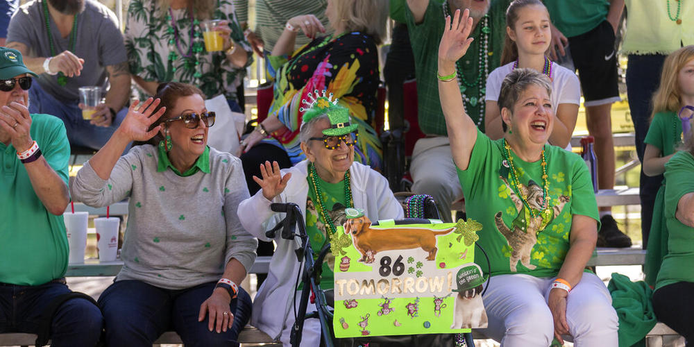 Mimi Rissman, 85, center, holds a sign announcing her 86th birthday while watching the St. Patrick's Day parade, Thursday, March 17, 2022, in historic downtown Savannah, Ga. After nearly two centuries, the Irish holiday has become Savannah's most profitable tourist draw and street party for hundreds of thousands of locals and visitors.