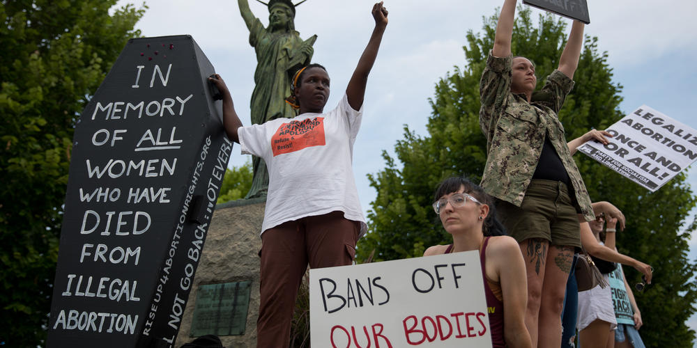 Protesters stand on the statues outside of the Georgia State Capitol on June 24 to protest the Supreme Court decision to overturn Roe v Wade. Georgia’s six-week abortion ban that has been held up by a district court will likely go into effect due to the ruling.
