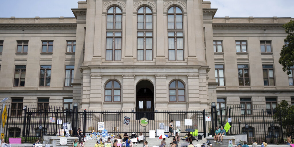 A small group gathers at the steps of the Georgia State Capitol protesting the overturning of Roe v. Wade on Sunday, June 26, 2022.