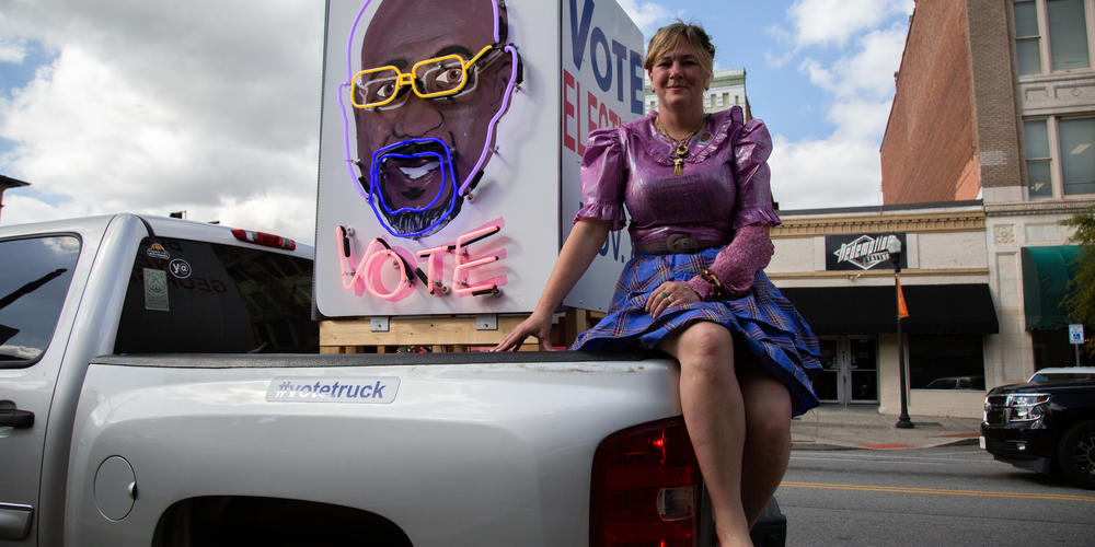 Rachel Lomas poses with her truck, the "#votetruck," all the way from Austin, Tx., on November 7, 2022 before a rally for U.S. Senator Raphael Warnock. "There's an energy here that isn't in Texas," Lomas says. "You know, there's hope here. ... I've kind of fallen in love with Georgia."