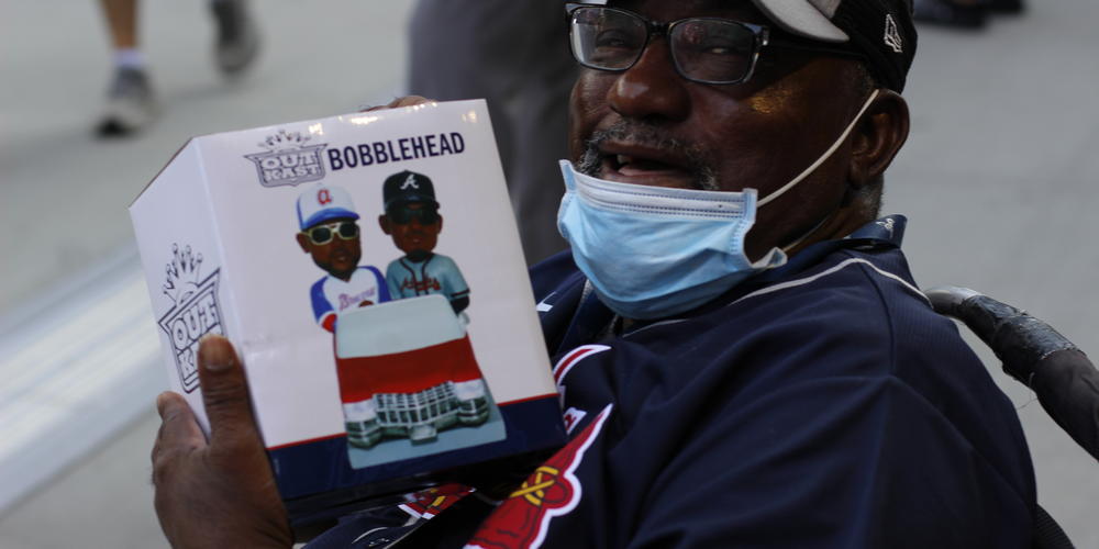 John Huggins of Atlanta shows off the OutKast bobblehead he received at the Braves game on May 25, 2023.
